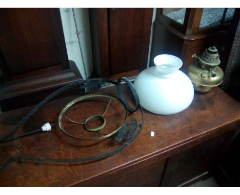 A wrought iron hanging brass oil lamp.