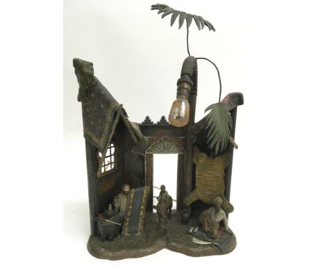 A large and unusual painted spelter or lead lamp, depicting Middle Eastern figures in a market place.Approximately 27x 35cm h