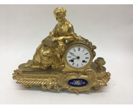A French gilt ormolu natal clock of classical form the enamel dial with Roman numerals flanked by a mail inset with a floral 