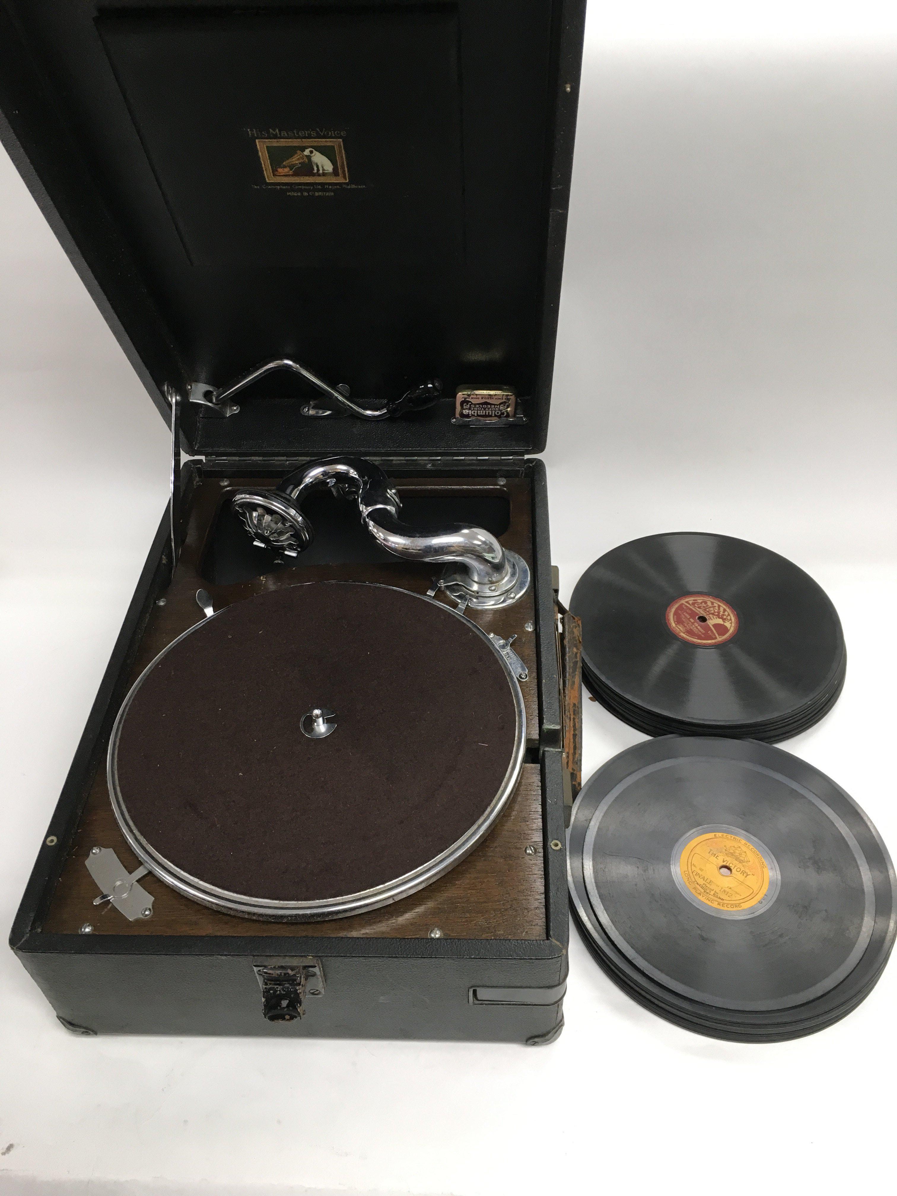 A portable HMV record player and various 10inch and 7inch vinyl records