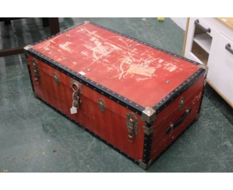 Red trunk containing rope and rug