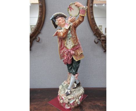 An early 20th Century ceramic figure of a gent with tambourine, 78cm height 