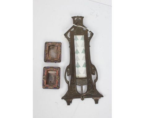 Art Nouveau pewter easel frame, of slender form, 26cm long, together with two small enamel decorated frames (3)