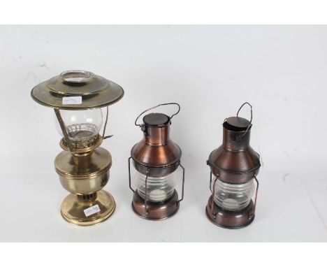 Pair of ships style copper effect candle lanterns, 24cm high, and a brass effect oil lamp (3)