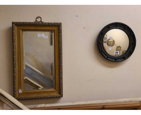A small ebonised framed convex mirror in the Regency style with easel back - sold with a modern gilt framed oblong wall mirro