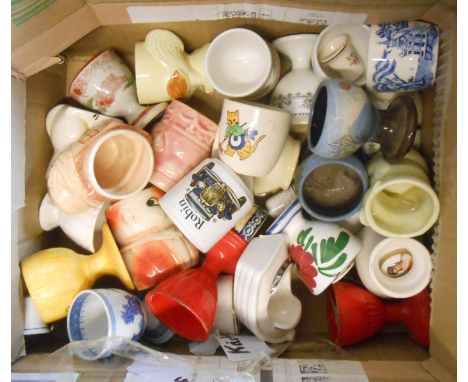 A box containing a quantity of ceramic and other novelty egg cups including Honiton boat, Boscastle Pottery mocha decorated, 