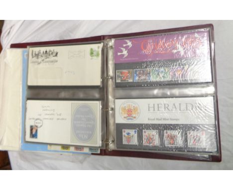 A red Royal Mail First Day Covers album containing plastic sleeve mounted mint decimal presentation stamp packs and FDCs dati