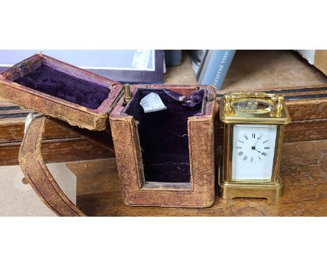 A brass and bevelled glass cased miniature carriage clock with platform escapement, in original leather clad travelling case