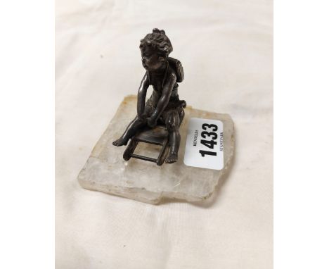 A small 19th Century silver plated figurine depicting a young girl on a sledge, set on a hardstone base