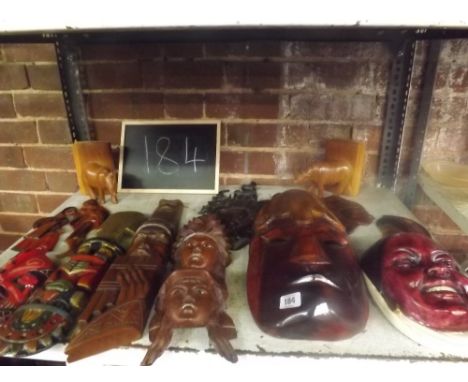 A SHELF CONTAINING MISC WOODEN ETHNIC ITEMS