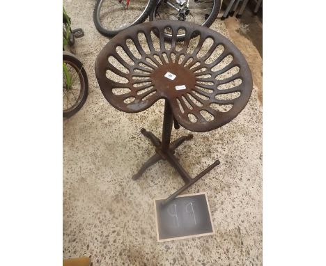 CAST IRON ADJUSTABLE BAR STOOL MADE FROM AN OLD TRACTOR SEAT ON FOUR FEET