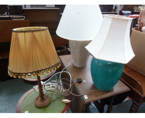 A turquoise lamp base, with two other lamp bases, with shades