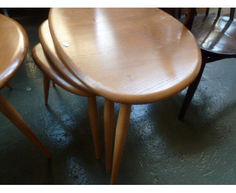 An Ercol light elm nest of three 'Pebble'; tables, largest 64cm