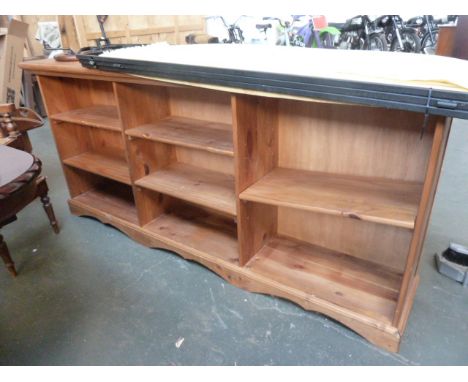 A large pine shelf unit, three sections, two with shelves, one with one shelf, with carved apron, 190cmW