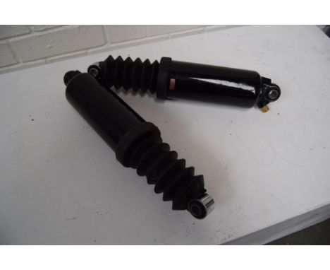 A pair of shock absorbers, believed to be for a Harley Davidson.
