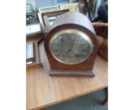 An early 20th century domed oak cased mantle clock, silvered dial with Roman numerals