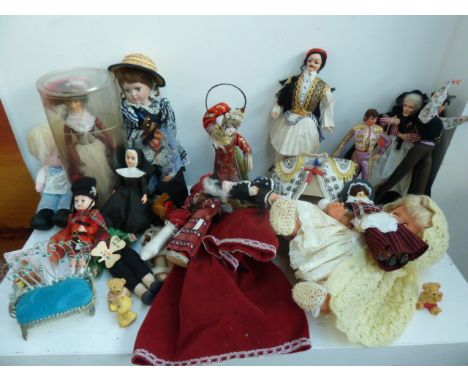 A box of dolls including a doll in a yellow dress with a woollen cloak, two rag dolls, an Anne Parker English Costume Dolls, 