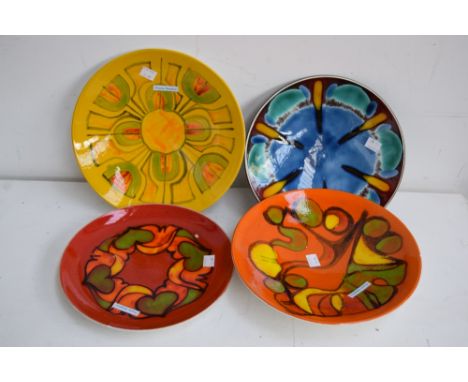 Four Poole Pottery 'Delphis' plates in various designs