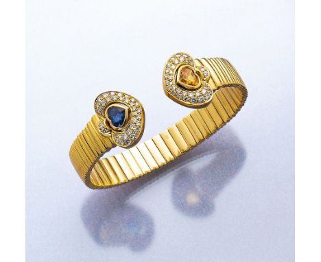 18 kt Gold Armspange mit Saphiren und Brillanten,   GG 750/000,   1 blaues und 1 gelbes facett. Saphir-Herz zus. ca. 70 Brill