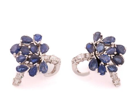 A pair of sapphire and diamond fruiting vine earrings, each composing a cluster of eleven pear-cut sapphires in deep blue col