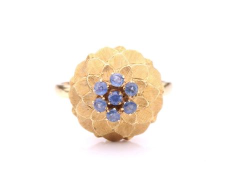 A sapphire-set dome ring, in the form of an artichoke, centrally set with a cluster of seven circular-cut sapphires in light 