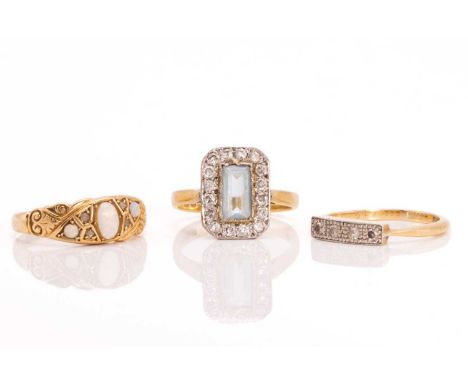 Three gem-set rings in 18ct gold; including an aquamarine dress ring, surrounded by a frame of single-cut diamonds, to a tape