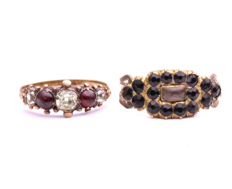 An early 19th century mourning ring and a 19th century five stone ring, the gilt metal mourning ring with rectangular crystal