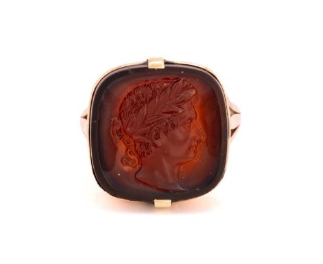 A carnelian cameo ring, the square cushion-shaped carnelian of dark brown colour, depicting a profile of a Roman emperor in a