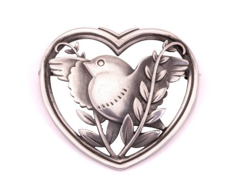 Georg Jensen - a heart-shaped brooch, depicting a flying dove with olive branches, fitted with hinged pin-stem and roll-over 