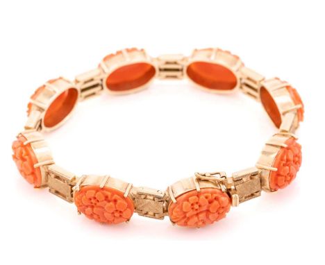 A coral line bracelet in 9ct gold, comprising eight oval precious coral plaques carved with flowerheads, in individual claw s