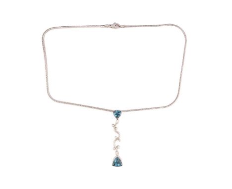 A topaz and diamond pendant on chain, the elongated vertical pendant comprises a wavy mount, interspersed with various sized 
