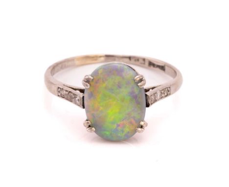 An opal and diamond dress ring, claw-set with an oval low-dome precious opal cabochon, displaying play-of-colour optical effe