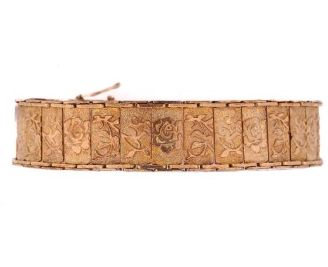 A yellow metal panel link bracelet decorated with scrolling flowering foliage, with a tongue clasp and double figure-of-eight