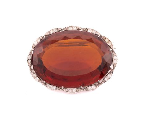 A large citrine and diamond brooch, featuring an oval-cut citrine of deep reddish orange colour, approximately measuring 4.0 