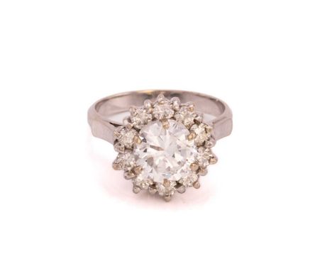 A diamond cluster ring, formed from a central round brilliant cut diamond measuring 8.12 x 4.73mm surrounded by ten claw set 