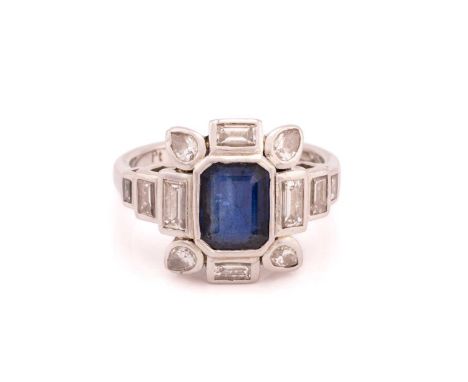 A sapphire and diamond dress ring, composed of an emerald-cut sapphire in dark blue colour, framed by baguette-cut and pear-c