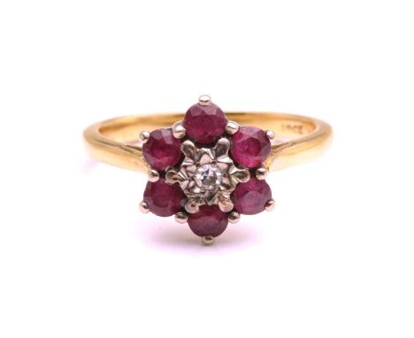 A yellow metal, diamond, and ruby floral cluster ring, illusion-set to centre with a round-cut diamond, measuring approximate