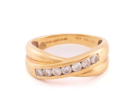 An 18ct yellow gold and diamond crossover ring, channel-set with seven round brilliant-cut diamonds, of approximately 0.33 ca