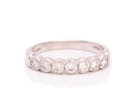 A seven-stone diamond half-eternity ring in platinum, seven brilliant-cut diamonds of 2.8 mm in a scalloped edge setting, to 