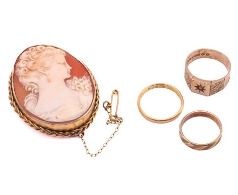 A shell cameo brooch and three rings, the brooch contains a shell cameo depicting a bust of a maiden with flowers, with braid