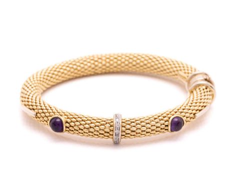 A gem-set hinged bangle in 18ct gold, consisting of flexible popcorn links, with two amethyst cabochons in collets and furthe