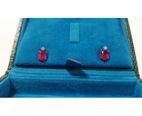 A PAIR OF 18 CT WHITE GOLD RUBY AND DIAMOND STUDS WITH RUBBERISED BUTTERFLIES, OVAL CUT RUBIES 2.00 CT, DIAMONDS 0.06 CT, BOX