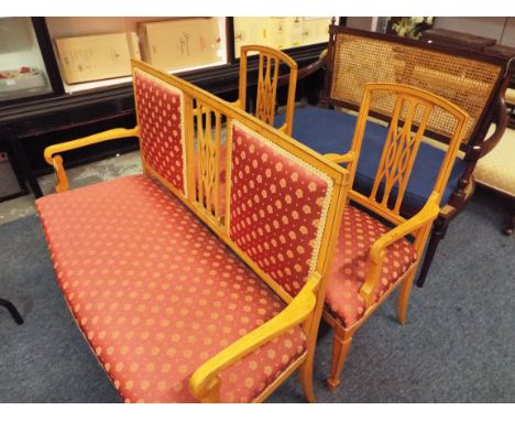 An Edwardian walnut ebony strung suite comprising upholstered two seater salon sofa, raised on tapering supports and spade fe