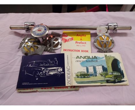 Three AA car badges, a Morris Minor car badge and three instruction books and one other