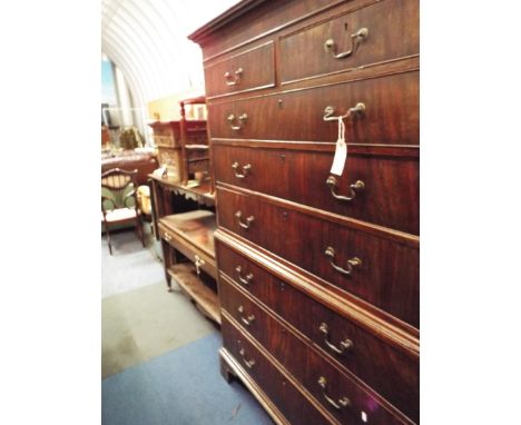 A George III flame figured mahogany chest on chest with moulded dentil cornice, brass swan neck handles and raised on bracket