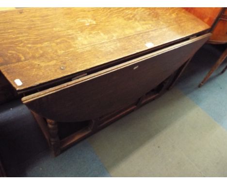 An early 18thC oak oval gate leg table raised on turned baluster supports