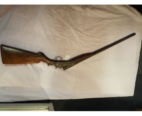 An unknown make antique single barrel 12 gauge shotgun, serial number CX462, the butt having been replaced by pack board, in 