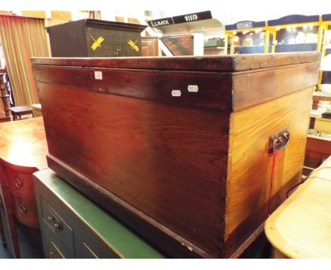 A Victorian stripped pine trunk fitted with iron handles and raised on a plinth base