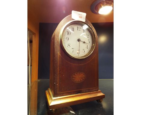 An Edwardian inlaid mahogany lancet shaped mantel clock with white enamel dial and Arabic numerals raised on brass bun feet 