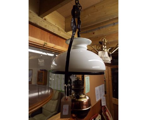 A late 19thC / early 20thC floral decorated wrought iron hanging oil lamp with brass reservoir stamped 'Lampe Veritas' with m
